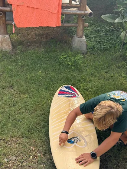 Me waxing my surfboard on the grass